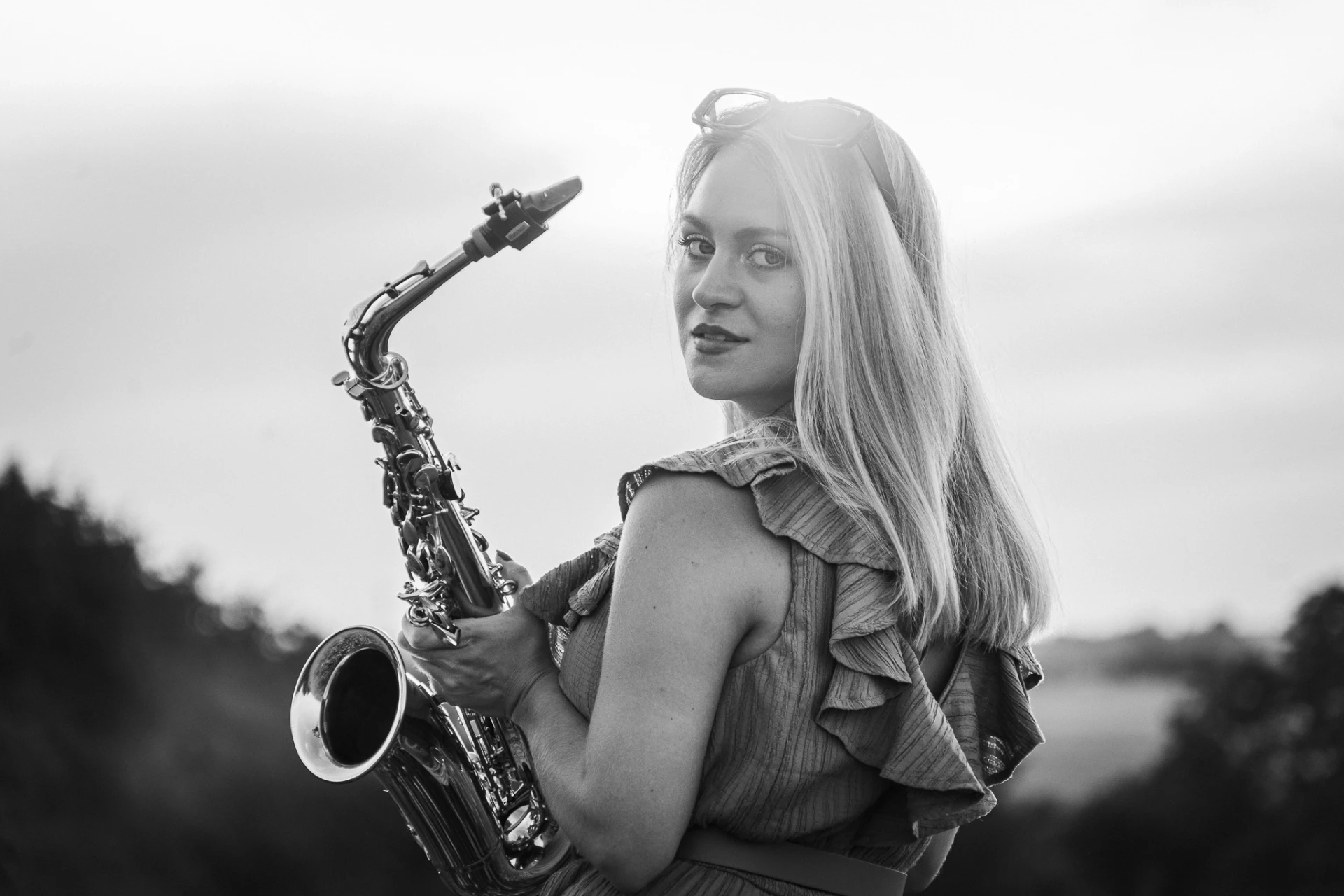 Černobílý portrét saxofonistky se saxofonem